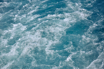 Fototapeta na wymiar Sea view from stern of yacht. Trace on water from yacht's engine. Sea foam. Copy space. Close-up. Selective focus.