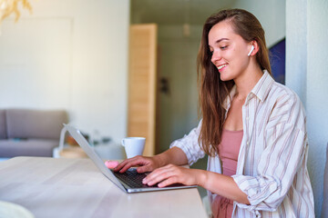 Young happy smart modern smiling cute satisfied girl browsing online using laptop
