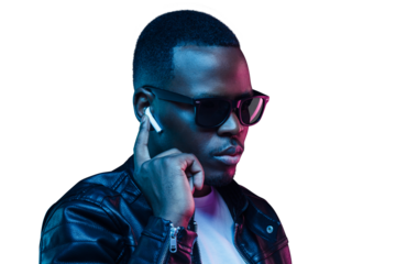 Dark-skinned guy dressed in leather jacket at night, listening to music via wireless earphones