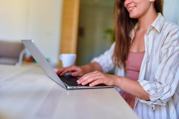 Female hands typing on laptop keyboard closeup