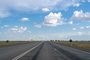 Lane on grey asphalt on empty highway among steppe