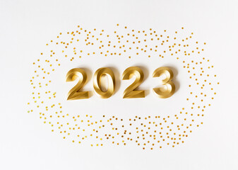Obraz na płótnie Canvas Greeting card - happy new year with numbers 2023 and gold glitter on white background.