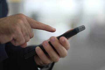 Confident businessman with formal suit using smart phone, smiling, talking and checking email.