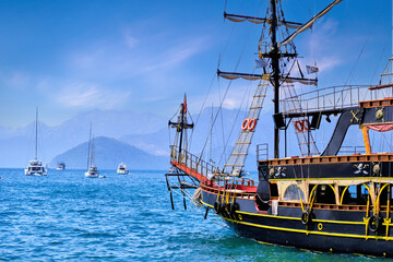 Wooden touristic pirate ship moored in a blue mediterranean lagoon
