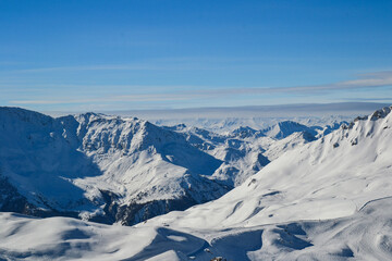 Fototapeta na wymiar Snow covered mountains under a blue sky