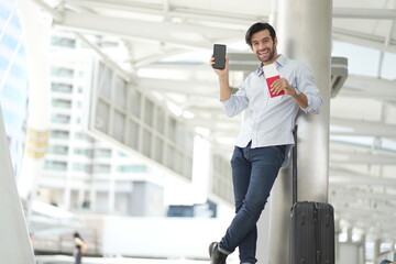 Traveler Man on smart phone - young man in airport. Casual urban professional businessman using smartphone Handsome Caucasian Man Relaxing With Smartphone While Waiting For Flight In Airport.