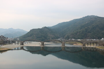 Fototapeta premium Scenic Mountain River and Historic Bridge in Rural Japan
