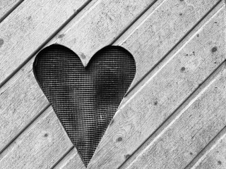 A window in the shape of a heart in a board wall