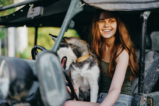 Woman and husky dog happily traveling in car smile with teeth fall walk with pet, travel with dog friend hugs and dances