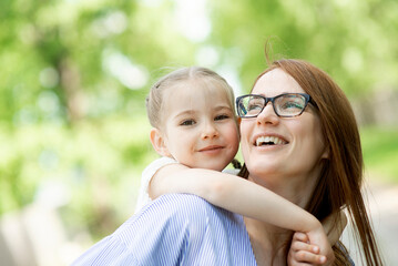 Portrait of happy mother daughter little girl child kid face family outdoors