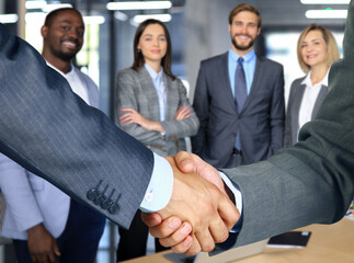 Business associates shaking hands in office