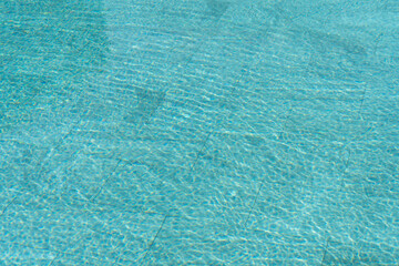 Swimming pool water background with caustic ripple. Aquatic surface with waves backdrop.