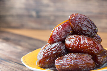 Delicious medjool dates ( kurma ) or sweet dried dates on a plate, as a meal for breaking the fast, ramadan kareem, empty space, copy space.