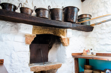 L’interno della cucina di una masseria in Salento con il vecchio forno e dei paioli di rame su una mensola © Andrea Vismara