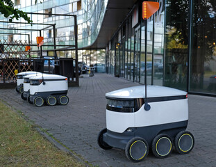 Autonomous delivery robot on Tallinn, Estonia. Estonian company developing autonomous delivery vehicles. Concept of future, technology, unmanned courier robot. - obrazy, fototapety, plakaty