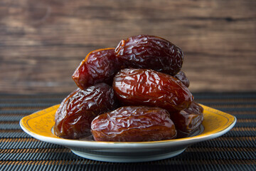 Delicious medjool dates ( kurma ) or sweet dried dates on a plate, as a meal for breaking the fast, ramadan kareem, empty space, copy space.