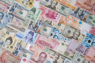 Top view of Various of international banknote include dollar Yuan Won Baht Peso for currency exchange and money transfer concept.
