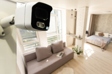 Close Up Object Shot of a Modern Wi-Fi Surveillance Camera on a White Wall in a Cozy Apartment Has Wi-Fi Icon Above it.