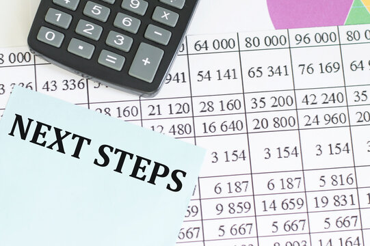 NEXT STEPS text on a blue card on the background of reports on the table next to the calculator