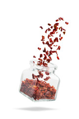 Glass container with falling spices. A burst of spices. Paprika