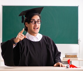 Graduate student in front of green board