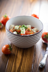 salad of fresh ripe tomatoes with mozzarella and spices in a bowl