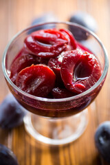 Sweet plums in syrup, in a glass bowl .