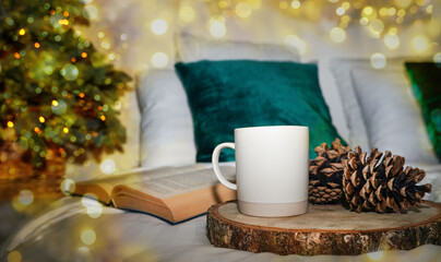 Christmas Tree with decorations on Christmas bokeh lights background. White cup or mug, mockup. Christmas and new year holidays concept