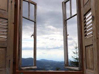 Der Blick geht durchs Fenster und in die Ferne hinaus auf Berge und Wälder. Geschossen im Schwarzwald.