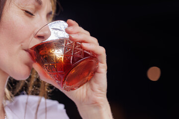 a girl drinks a negroni cocktail on the terrace of a modern restaurant