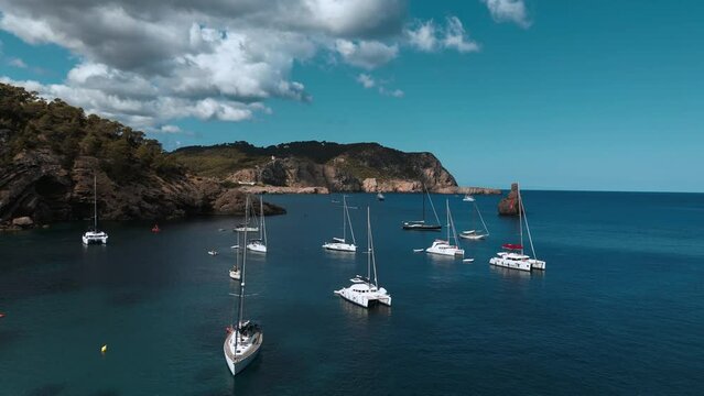 aerial shot of sailing yachts beach bay beautiful Mediterranean blue water sky view on the balearic islands of ibiza