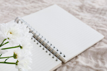 開いたノートと白い花