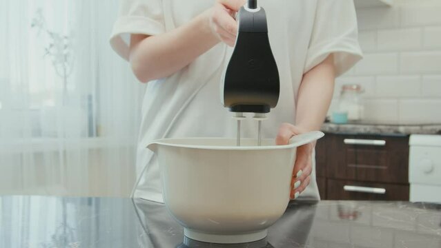 Mom Making Dough For Cupcakes With A Mixer In A Bowl With Egg, Flour And Milk