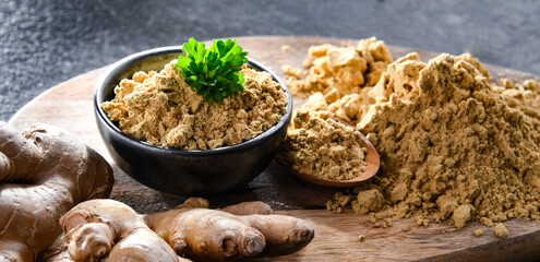 A bowl with ground ginger and its fresh rhizome