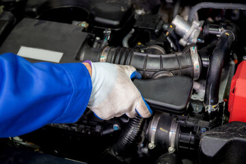 Closeup hands of man is mechanic repairing engine of car in the garage, auto service, worker fix and adjusting part of automobile with problems in the station, transportation and automotive concept.