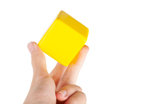 Hand holding up a simple plain yellow floating hovering cube element or node grabbing it between fingers, isolated. Network app, application interface smart human interaction gesture abstract concept