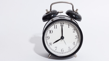 black vintage style alarm clock isolated on a white background