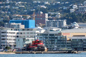 Stunning cityscape and waterfront view of harbour, tugboat, residential apartments and urban inner city offices in the Capital Wellington, New Zealand Aotearoa - Powered by Adobe