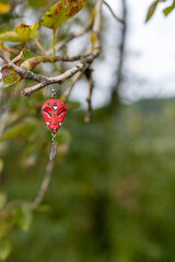 Obraz premium An earring in the form of an African mask hangs on a tree branch