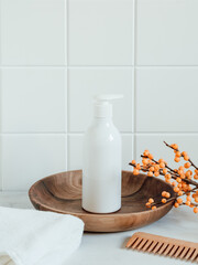 White plastic bottle with pump mock up, used for shampoo and conditioner for hair on wood tray and wood comb