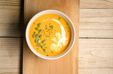 Yellow Pumpkin Soup on wooden background. Horizontal. Top view.