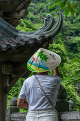 Photograph of a female traveler visiting a pagoda in Vietnam. Traveling on vacation. Buddhist temple