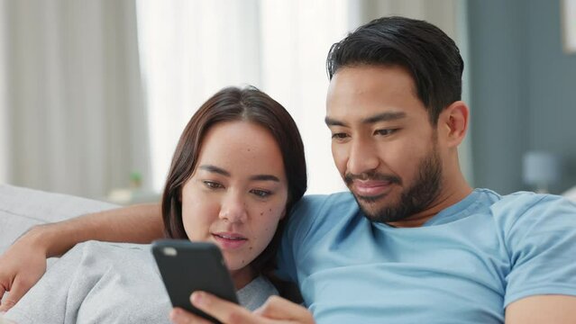 Young, happy and asian couple taking a selfie together at home. Chinese woman and man take a picture on smartphone and look at it. Laughing, fun and smiling people in relationship