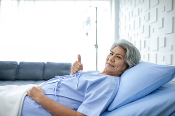 An elderly woman thumbs up and smiling as the doctor examines the condition in the recovery room. Healthcare and medicine concept. - 531461183