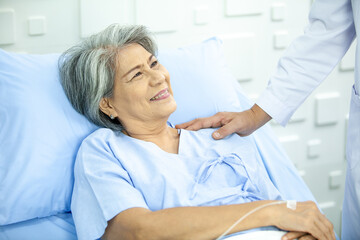 Obraz premium Asian doctor supporting and cheering up senior patient in hospital, talking smiling in comfort. Healthcare and medicine concept.