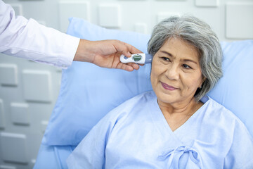 doctor is measuring the temperature of senior patient at ear in the hospital, Healthcare and medicine concept.