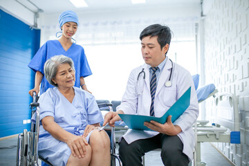 Obraz premium asian doctor with stethoscope and document folder, examine the symptom for senior patient in the recovery room. Healthcare and medicine concept.