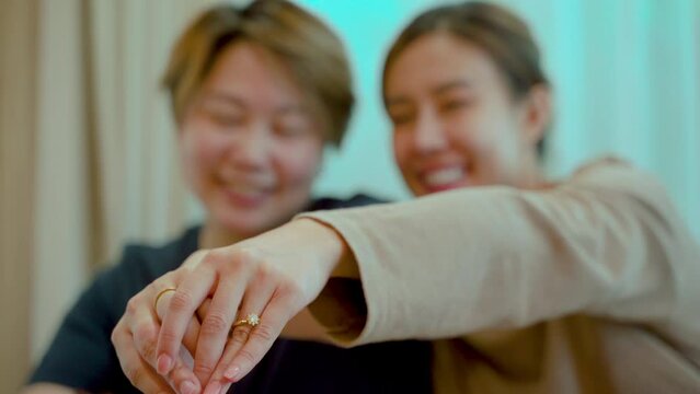 4K, Close Up The hands of two female couples showing off their wedding rings after they moved into their new home after getting married. Love and friendship of LGBTQ couples