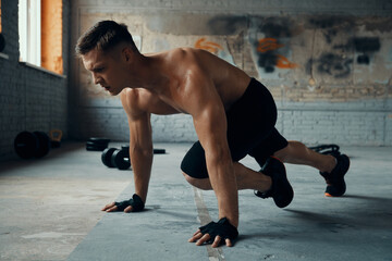 Obraz premium Confident young man looking concentrated while exercising in gym