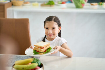 Duaghter happy and smile for serve sandwich to parent in home kitchen
